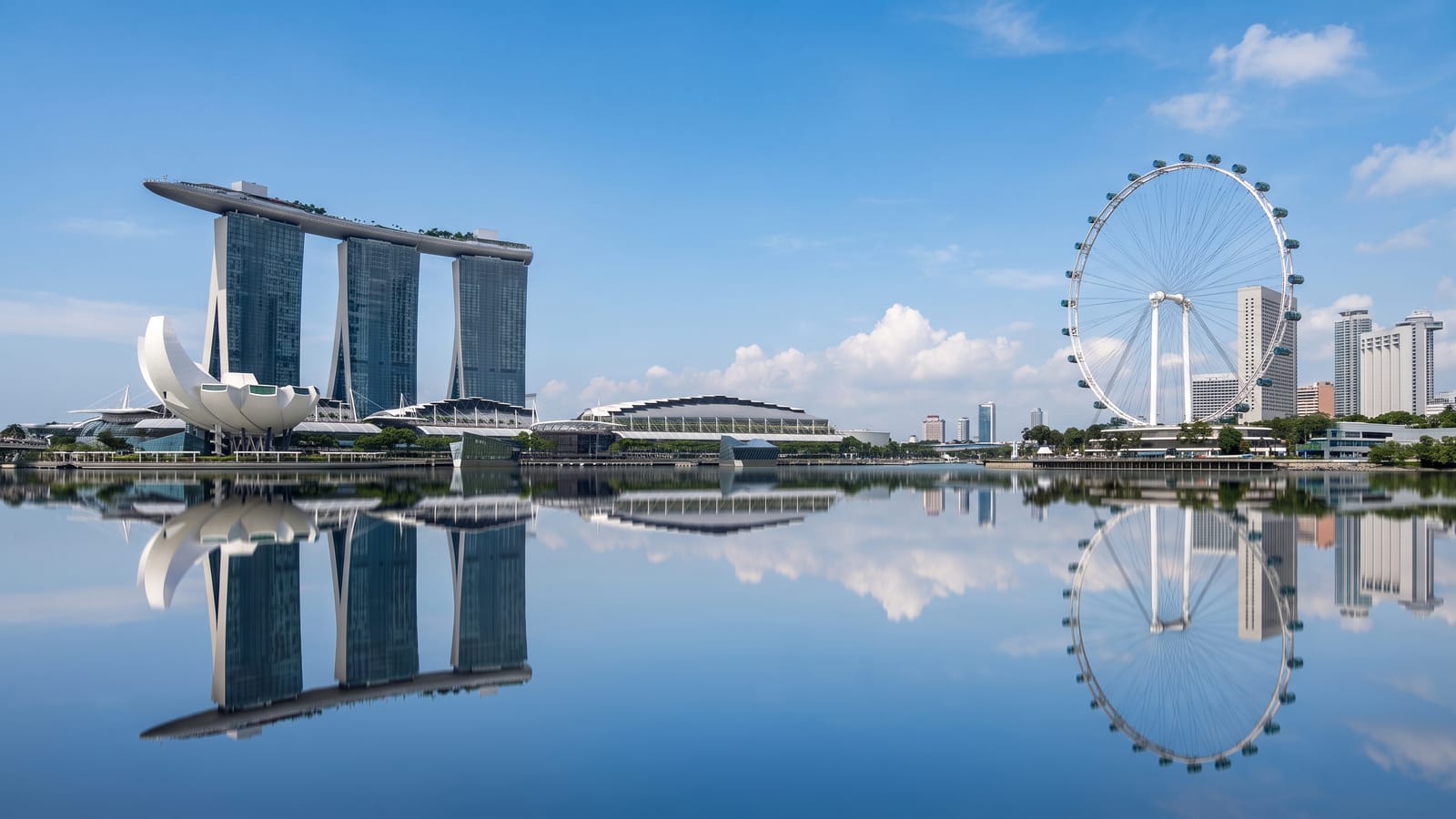 The Marina Bay skyline in Singapore in daylight, seen across the water from the promenade.